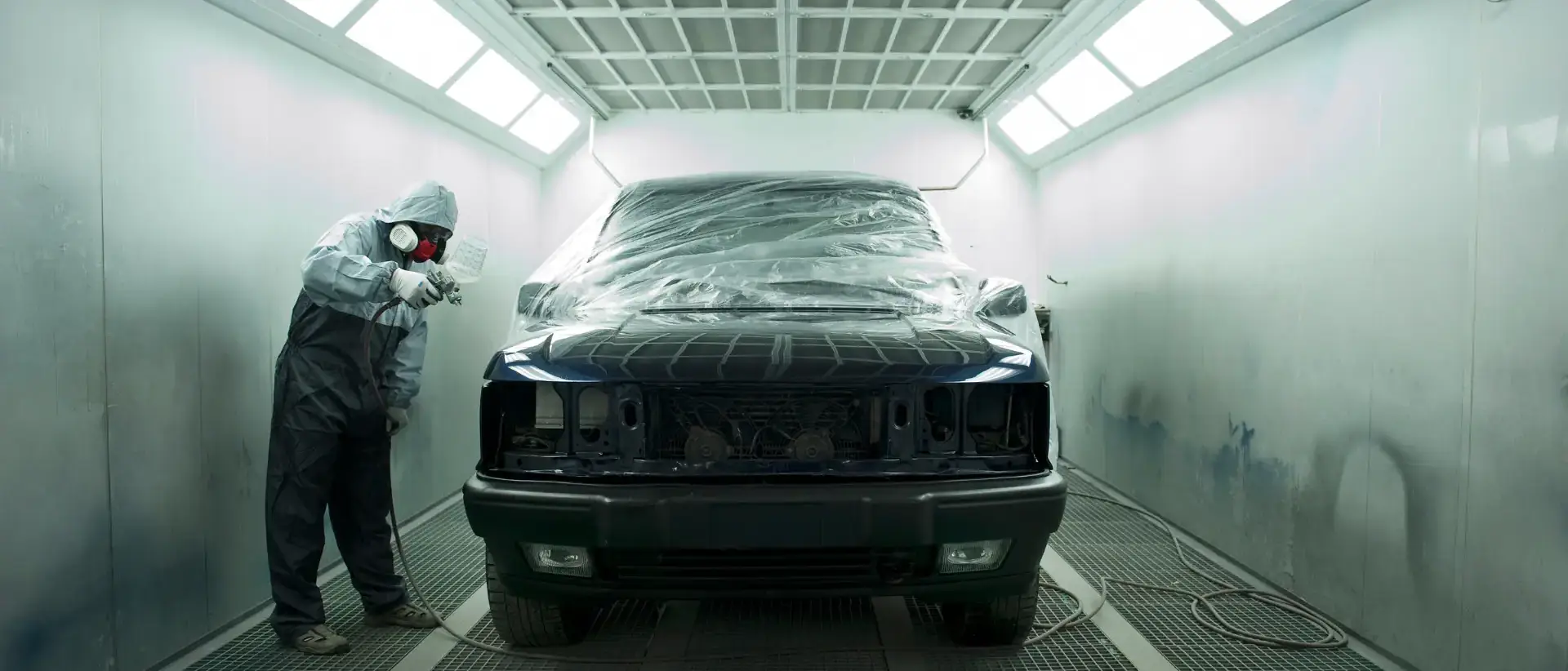 Car being painted in paint booth.